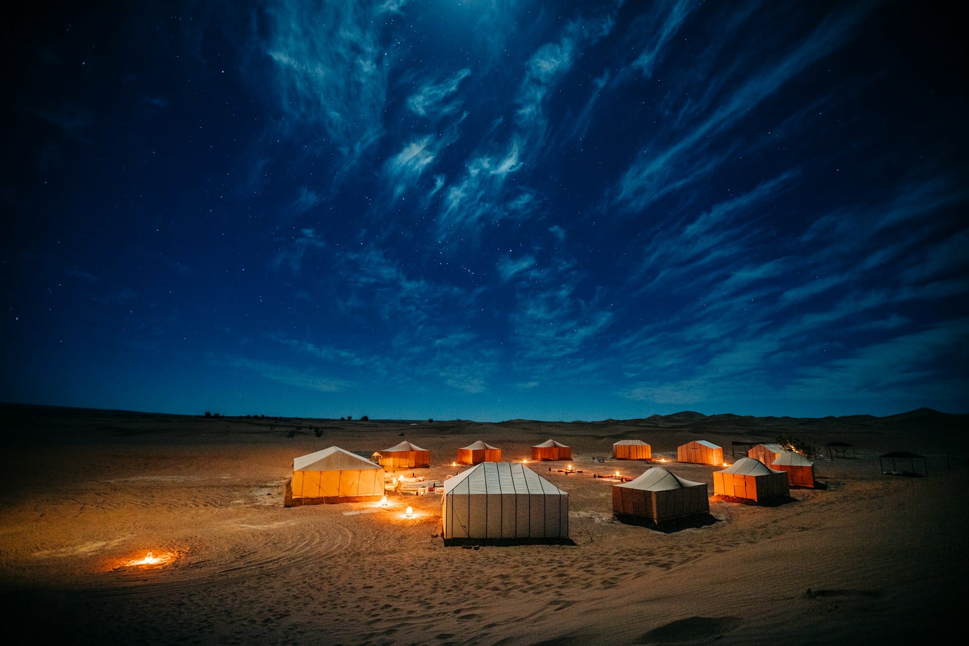 Desert camp at night beneath a clear starry sky in the Moroccan desert