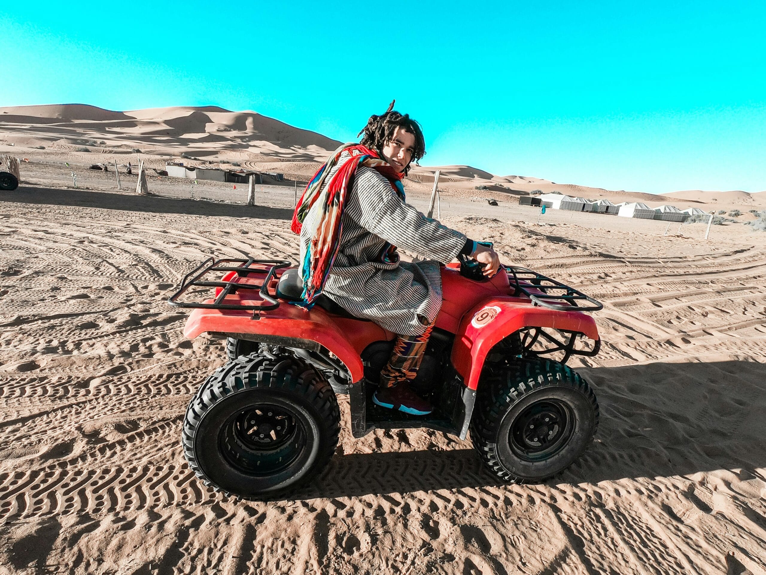 Man riding a quad bike across the sand dunes in the Moroccan desert