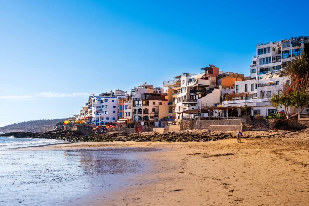 Taghazout, small fishing and surfing village with sandy beach and traditional Moroccan buildings near Agadir, Morocco. Popular seaside resort among surfers.