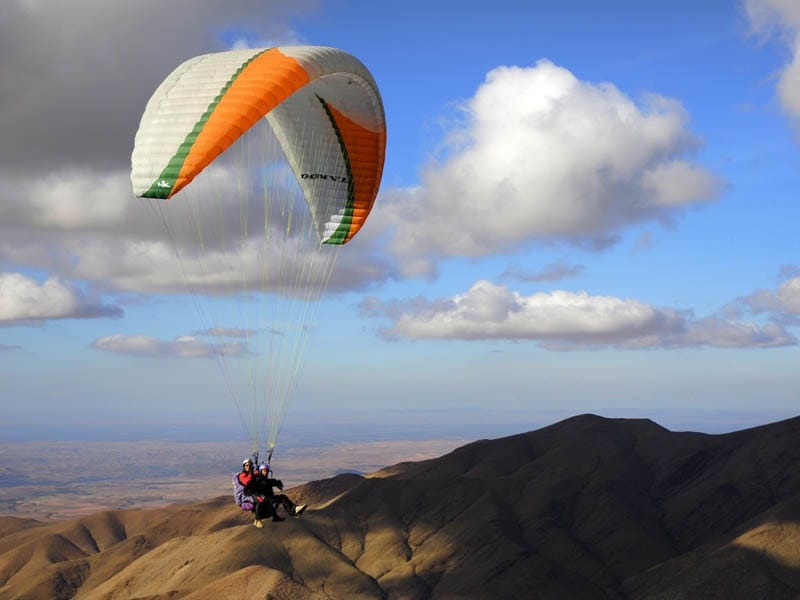 Tourist flying by paraglider over the High Atlas Mountains in Morocco